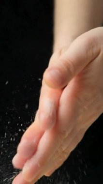 Siyah bir arka planda toz un pişirirken ellerin yavaş çekim görüntüsü..