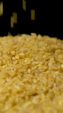 Pişmemiş bulgur buğday dökülmüş. makro dikey ağır çekim