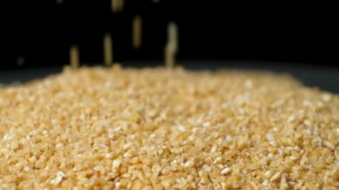 Çiğ pişmemiş buğday Groats dökülüyor, makro yavaş çekim