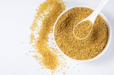 Pişmemiş bulgur, kaşık ve tabak üst görüşünde buğdayı çatlattı..