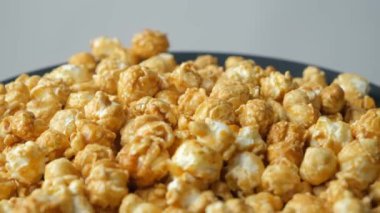 Karamelli patlamış mısır rotasyonu, gri arkaplan.