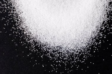 Macro crystals of white rock edible salt on black background space for text. clipart