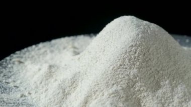 Siyah zemin üzerinde yavaş yavaş tam tahıl unu yığını