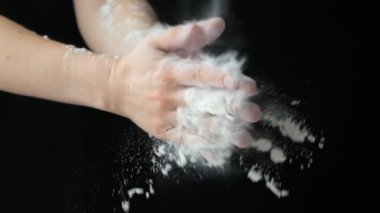 Aşçı ellerini unla çırpıyor, un sıçrıyor ağır çekimde.