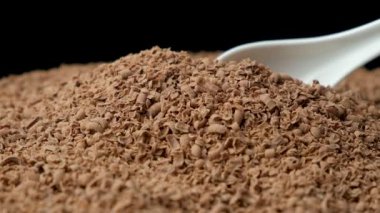 Bir kaşıkta sütlü çikolata parçacıkları, makro yavaş çekim.
