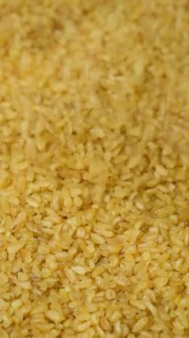 Pişmemiş bulgur buğday dökülmüş. makro dikey ağır çekim