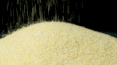 Pişmemiş irilmemiş irmik gevreği dökülüyor, makro yavaş çekim.
