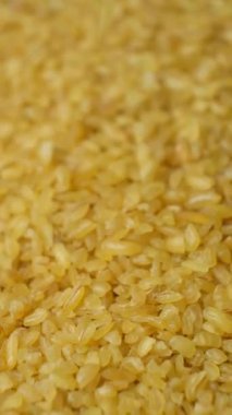 Pişmemiş bulgur buğday dökülmüş. makro dikey ağır çekim