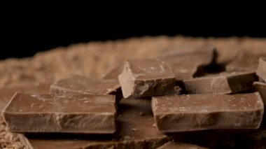 Siyah arkaplanda sütlü çikolata parçaları, siyah arkaplanda döndürme.