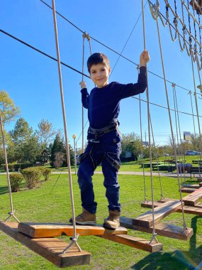 Çocuk halatlarıyla macera parkında yedi yaşında bir çocuk..