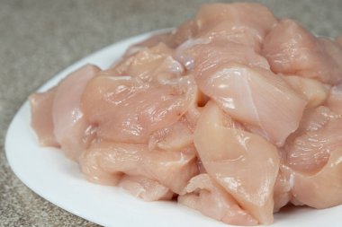 Bir tabakta pişmemiş taze çiğ tavuk filetosu.