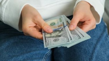 Ellerinde bir yığın 100 dolarlık banknot, birikim konsepti.