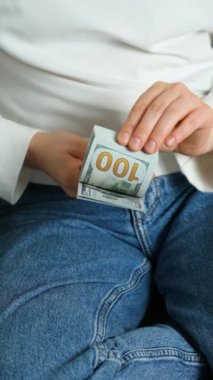 Ellerinde 100 dolarlık banknotlar, biriken para konsepti, dikey ağır çekim