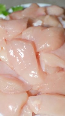 Dönen çiğ tavuk filetosu parçalara ayrılmış, dikey ateş edilmiş.