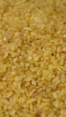 Pişmemiş bulgur buğday dökülmüş. makro dikey ağır çekim