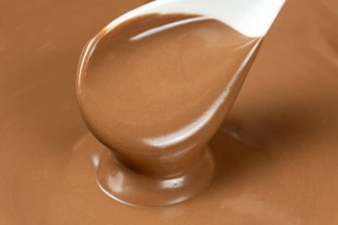 Erimiş sütlü çikolata bir kaşıktan döküldü.