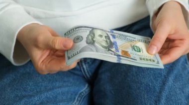 Ellerinde bir yığın 100 dolarlık banknot, birikim konsepti.