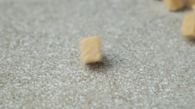 Kahverengi kamış şeker küpleri taş zemine düşüyor, yavaş çekim.