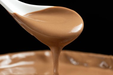 Erimiş sütlü çikolata bir kaşıktan döküldü.