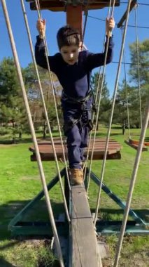 Çocuk halatlarıyla macera parkında yedi yaşında bir çocuk..