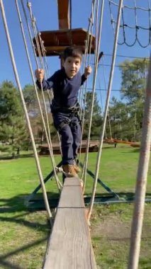 Bir çocuk halat parkında engelleri aşıyor.