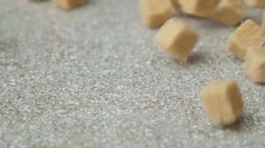 Kahverengi kamış şeker küpleri taş zemine düşüyor, yavaş çekim.