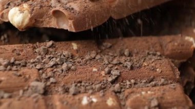 Çikolata parçacıkları ağır çekimde ağır çekimde fındık çikolatalarının üzerine dökülüyor.