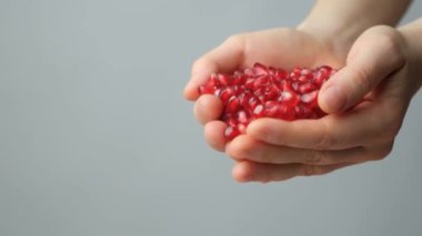 Eller nar tohumları döküyor, yavaş çekim.