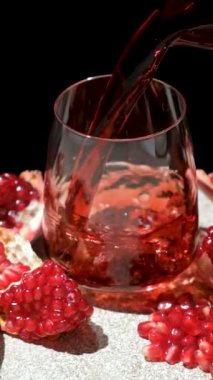 Sürahiden cama akan nar suyu, siyah arkaplan, yavaş çekim dikey çekim