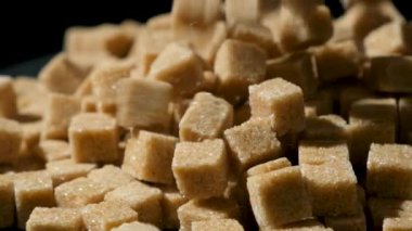 Kahverengi kamış şeker küpleri yığının üzerine düşüyor, makro yavaş çekim