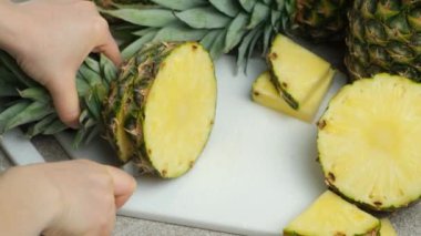 Eller taze ananas meyvelerini yavaş çekimde parçalara ayırıyor..