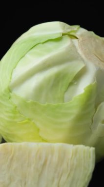 Siyah arka planda taze lahana sebzelerinin dönüşümünün dikey çekimi