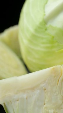 Siyah arka planda taze lahana sebzelerinin dönüşümünün dikey çekimi