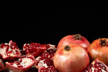 Ripe pomegranates, peeled and whole, place for text. clipart