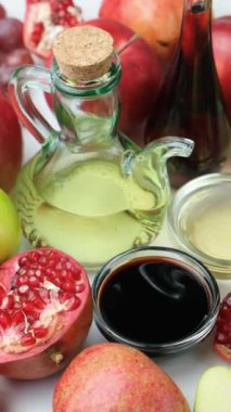Meyvelerin arasında sirke kaselerinde farklı türde elma, şarap ve nar var.