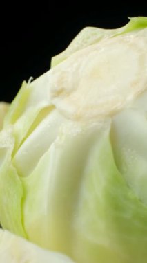 Siyah arka planda taze lahana sebzelerinin dönüşümünün dikey çekimi