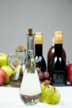 White wine vinegar in a vinegar bowl against the background of other types of bottled vinegars. clipart