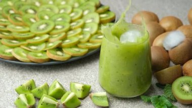 Buz küpleri yeşil kiviye düşüyor. Naneli smoothie yavaş çekim.