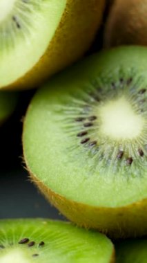 Bir sürü taze dilimlenmiş kivi, dikey video, yavaş dönüş.