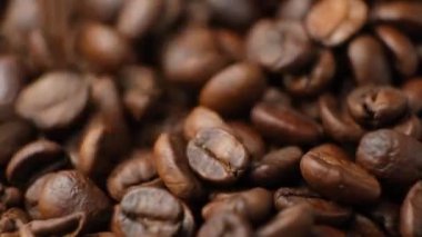 Kafeinsiz kahve çekirdekleri ağır çekimde makro kahve dolduruyor.
