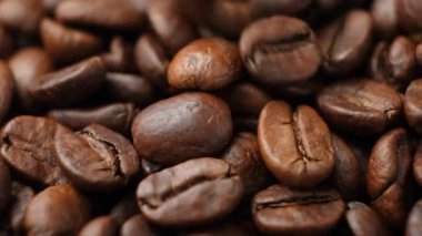 Kafeinsiz kahve çekirdekleri ağır çekimde makro kahve dolduruyor.