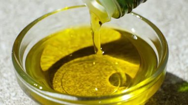 Rafine edilmemiş ekstra saf zeytinyağı şişeden ağır çekimde akıyor.