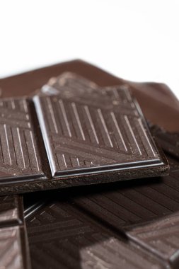 Beyaz arka planda siyah çikolata parçaları, makro doku..