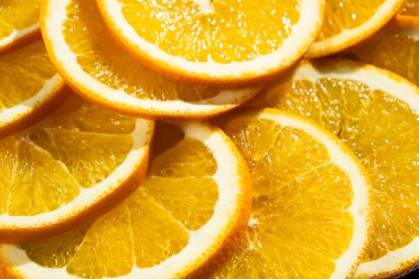 Turuncu arkaplan, olgun portakallar yakın plan dilimlere kesilmiş.