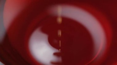 Koyu aromatik yağ dökülmesi, kabarcıklar, yavaş çekim makrosu.