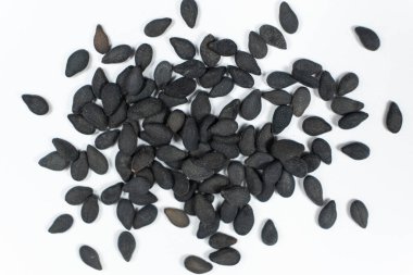 Black sesame seeds scattered on a white background macro top view. clipart