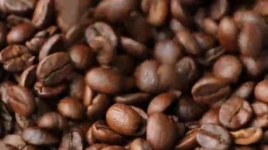 Kafeinsiz kahve çekirdekleri ağır çekimde makro kahve dolduruyor.