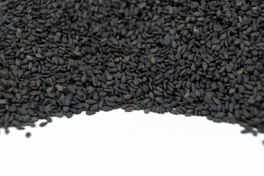 Siyah susam tohumları beyaz bir arkaplan üzerine yayılmış metin için.