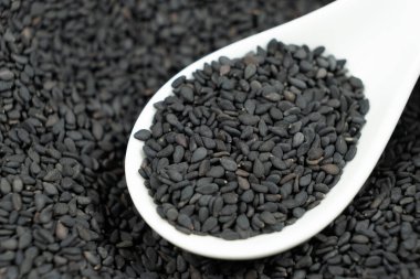 Bir kaşık makroda doğal siyah susam taneleri..