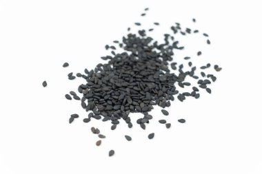 Siyah susam tohumları beyaz arka plan makro yan görünümüne saçılmış..
